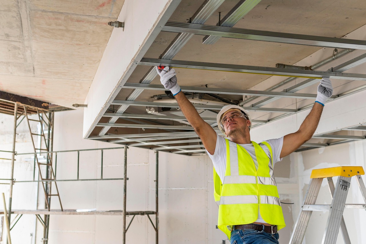 MEP technician installing a suspended ceiling frame on a commercial project